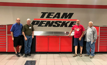 Kyle Pinkerton (far left) shows his uncles Rick (second from left) and Tim Pinkerton, along with a family friend, around the Team Penske shop.